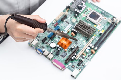 半田ゴテが長すぎてプリント基板の修理作業に難儀する様子