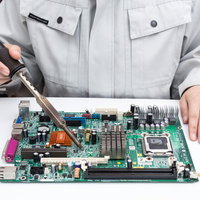 半田ゴテでプリント基板を修理する作業員の電子部品はんだ付け作業の写真