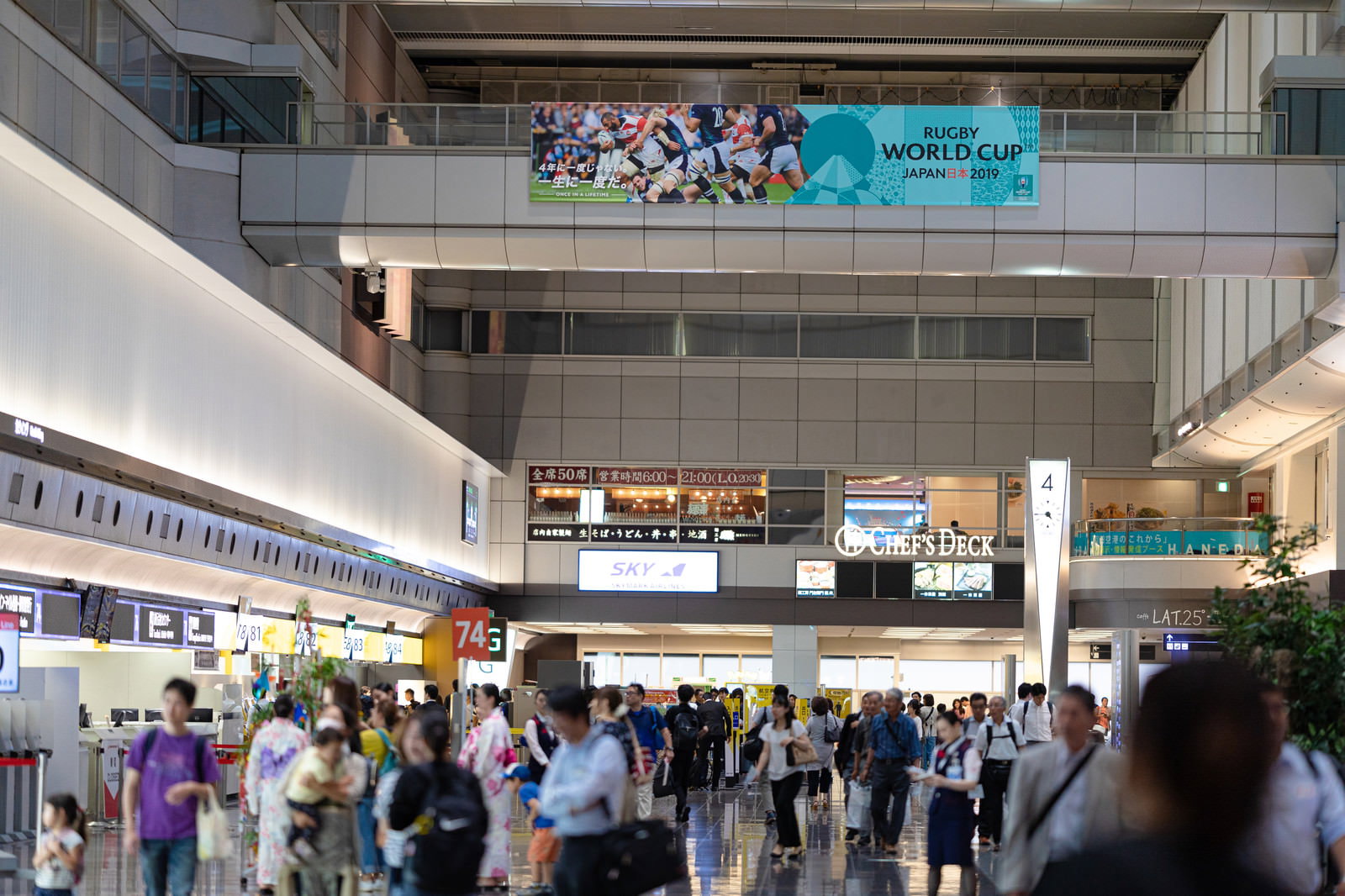 ラグビーワールドカップの広告が掲げられた羽田空港ターミナル内の混雑した様子