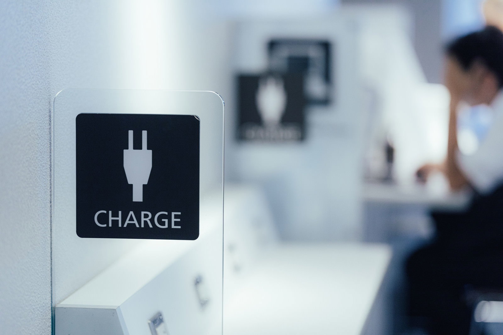 空港内に設置された白い充電ステーション、CHARGEの文字が見える
