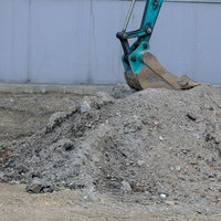 工事現場で土を掘削する黄色いショベルカーの重機作業の写真