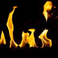 暖炉で立ち上がるオレンジ色の炎が輝く温かい火の風景の写真