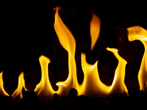 黒い背景にメラメラと燃え上がる炎の写真