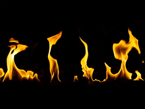 黒い背景に立ち上るメラメラ炎の炎と熱の表現