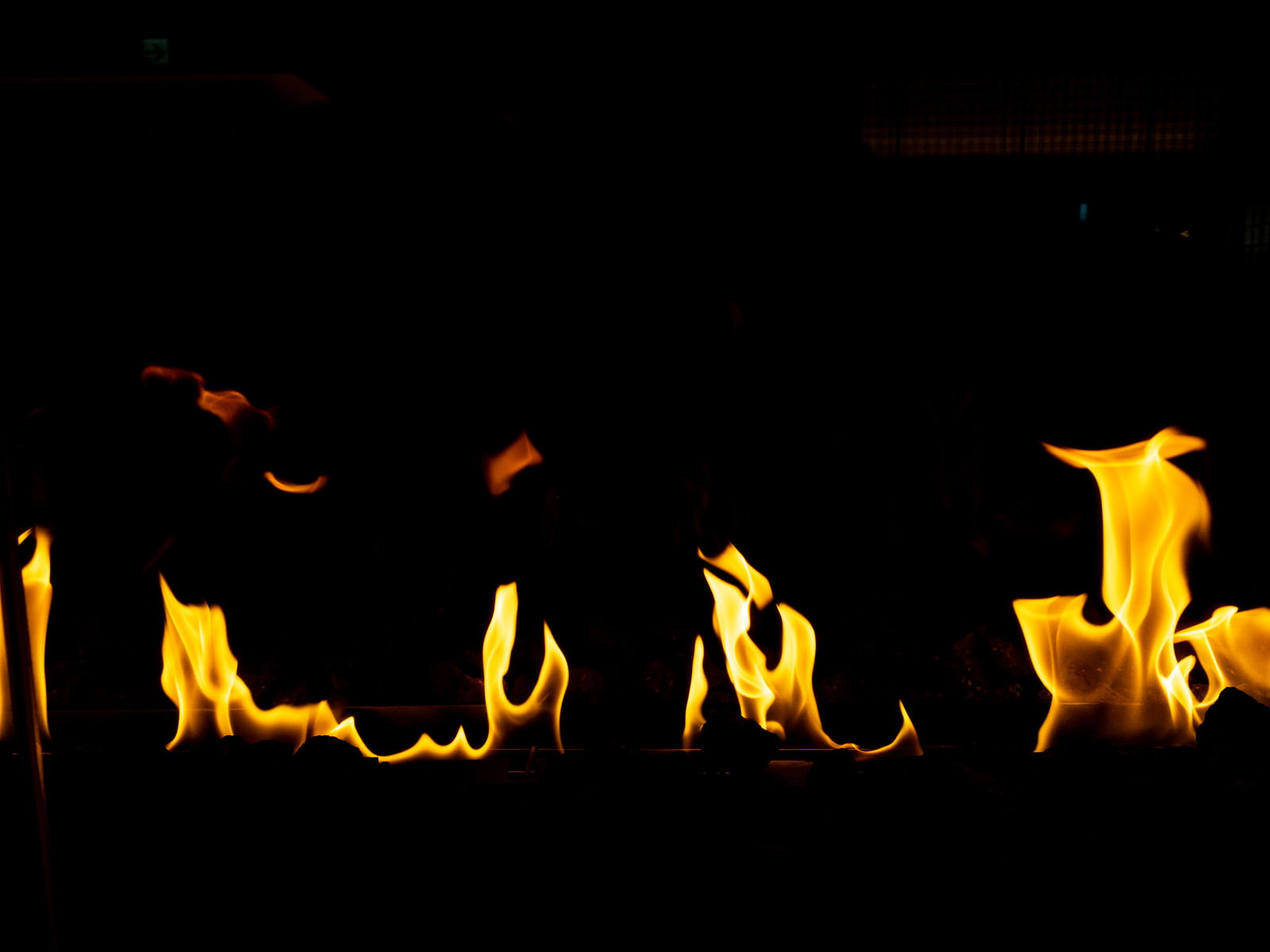 黒い背景に黄色とオレンジ色の炎が激しく燃え上がっている様子