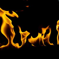 黒背景に燃え上がるストーブの炎が躍動的に立ち上るの写真