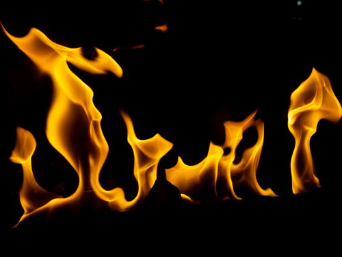 黒背景に燃え上がるストーブの炎が躍動的に立ち上る