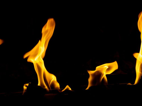 黒背景で燃えあがる炎のメラメラした火焔とオレンジ色の明火