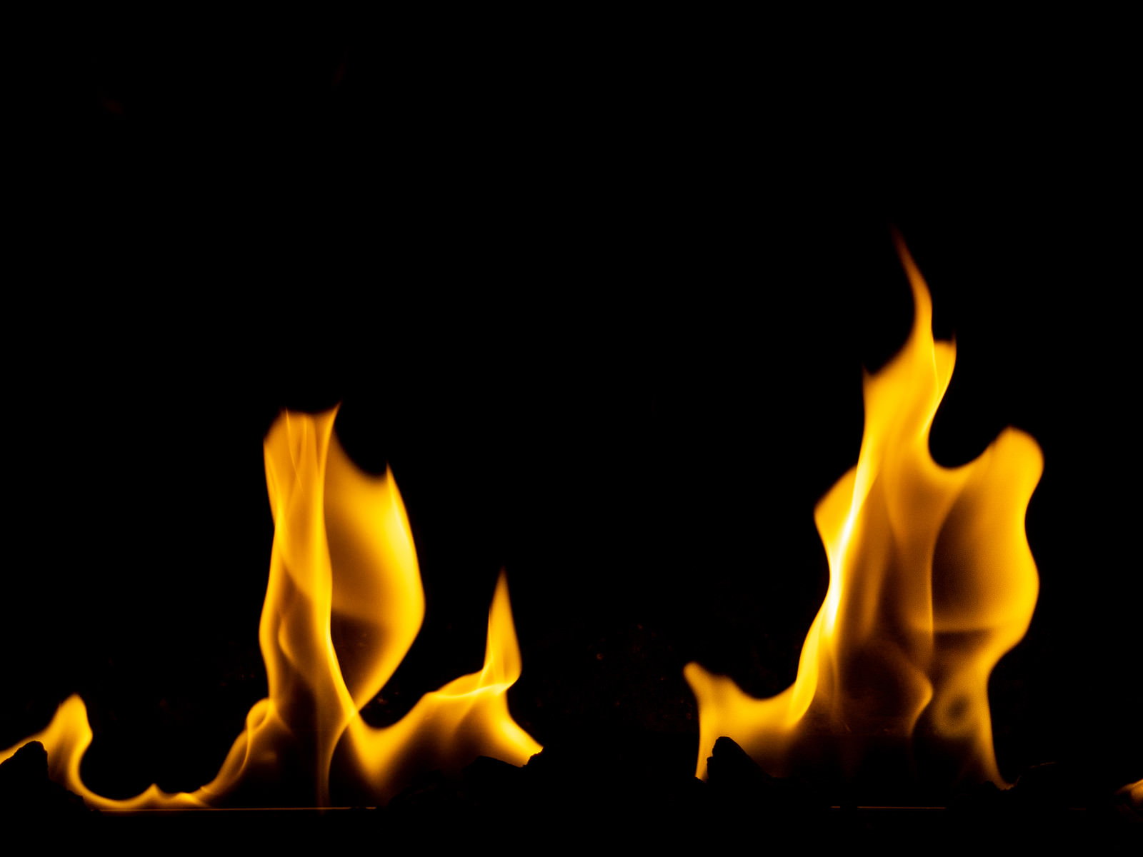 黒い背景にオレンジ色の炎が複数立ち上がっている