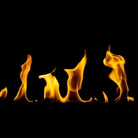 黒背景に立ち上がる炎の演出。オレンジ色の燃え上がる炎の写真