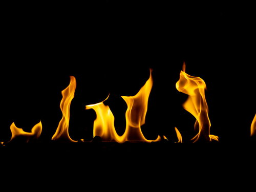 黒背景に立ち上がる炎の演出。オレンジ色の燃え上がる炎