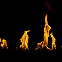 黒背景にメラメラ燃え上がる炎の写真の写真