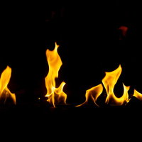 黒い背景にめらめらと炎が上がる躍動感のある炎の写真