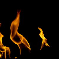 黒背景に立ち上がるオレンジ色のメラメラした炎の写真