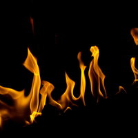 揺らぐオレンジ色の火と炎、キャンプファイアの背景の写真