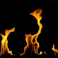 黒背景に映える橙色の焔（ほのお）が激しく燃え上がる炎の写真