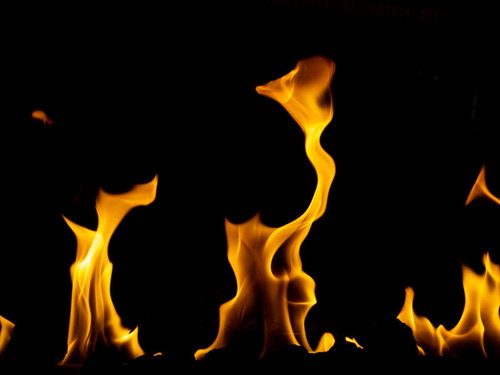 黒背景に映える橙色の焔（ほのお）が激しく燃え上がる炎