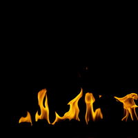 黒背景から立ち上がるオレンジ色の炎が燃え盛るの写真