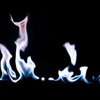 黒い背景に青白く燃え上がるガスの炎が激しく燃焼するの写真