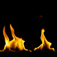 黒い背景に立ち上がるメラメラと燃え広がる炎の写真