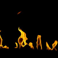 黒い背景に横に燃え広がる炎のテクスチャの写真