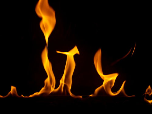 黒背景に燃え始める炎の炎の表現、メラメラと燃え上がる炎