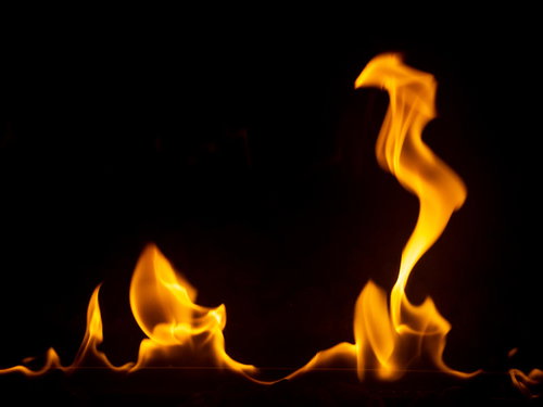 黒背景に燃えたぎる炎の躍動感あふれる炎のメラメラとした火炎
