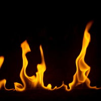 黒背景で勢いよく炎を燃え上がらせるメラメラとした火の写真