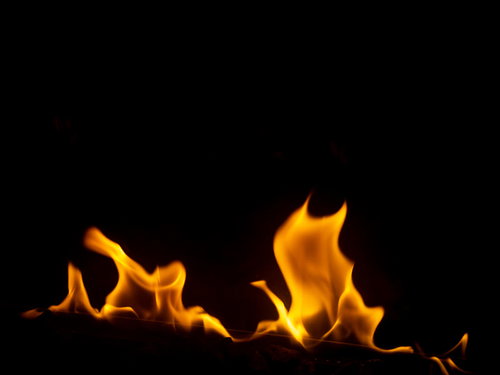 黒背景に揺らめく消えそうな炎のメラメラと燃える炎