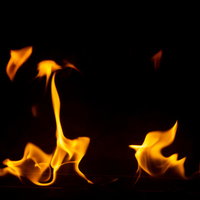 黒い背景に立ち上がる燃え始めの炎が揺らめく様子の写真