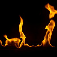 黒背景に立ち上がるメラメラとした炎を上げて燃える火の写真