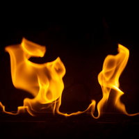 力強いメラメラと躍動する炎のエネルギー、黒背景で輝く燃える炎の写真