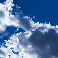 青空に浮かぶ白い雲の黒い影の写真