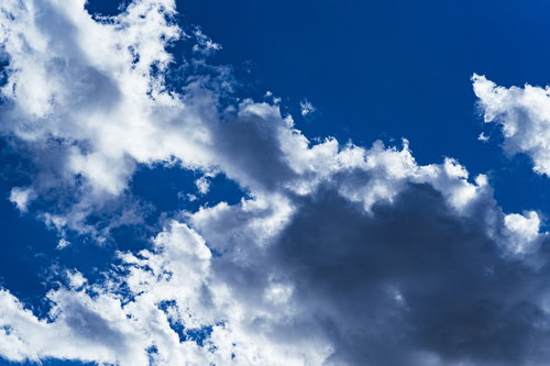 青空に浮かぶ白い雲の黒い影