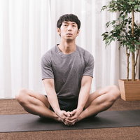 ストレッチ中に考え事をするトレーニング中の男性の写真