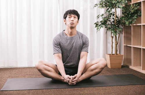 ストレッチ中に考え事をするトレーニング中の男性