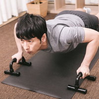 プッシュアップバーで腕立て伏せをするトレーニング中の男性の写真