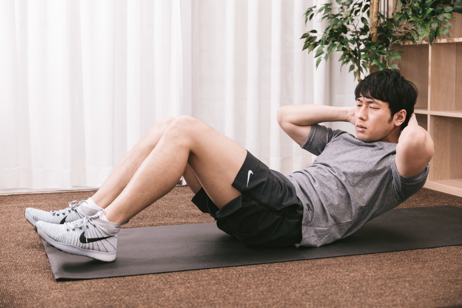 腹筋ローラーでトレーニングする男性［モデル：大川竜弥］