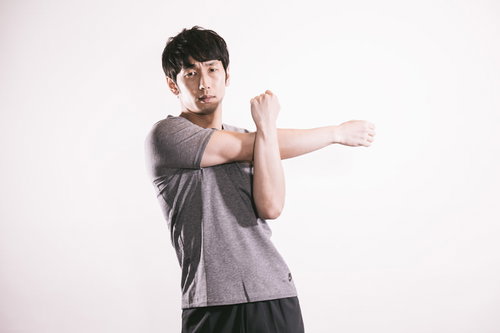 上腕三頭筋を伸ばす準備運動をする男性のストレッチ