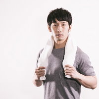 マイタオルを持参するトレーナー男性がスポーツジムで立つの写真
