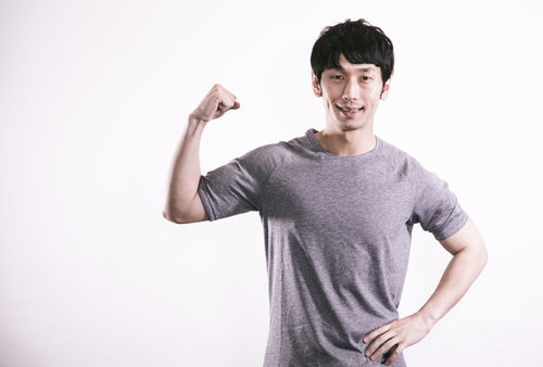 力こぶを披露するトレーニング中の男性の筋肉