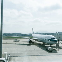 空港のターミナルに駐機する旅客機とボーディングブリッジの写真
