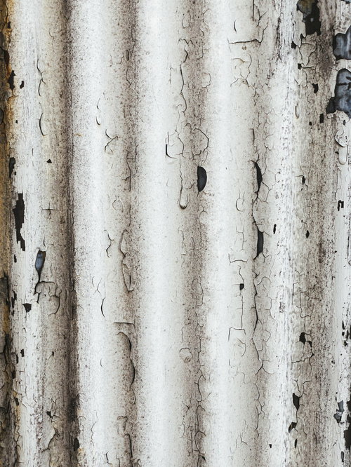 白い塗装が剥がれかけるトタンのテクスチャー