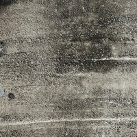 シミと汚れが残るアスファルト路面のテクスチャーの写真