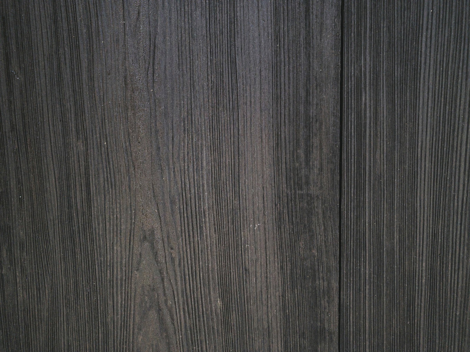縦方向に流れるダークグレーの木目が美しい板のテクスチャー