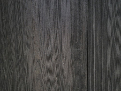 幾千もの木目が流れるダークグレーの板