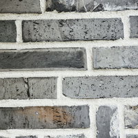 厚めの目地が際立つグレーのレンガ壁のテクスチャーの写真