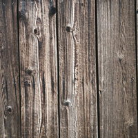 縦並びの古い木板に浮き出た濃い木目と節穴のテクスチャーの写真