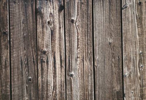 縦並びの古い木板に浮き出た濃い木目と節穴のテクスチャー