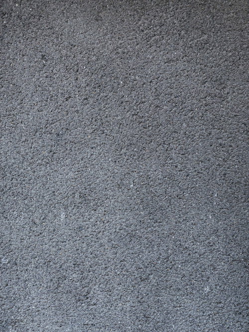 粗いアスファルトの地面と砂利混合の舗装面